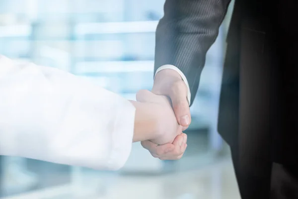 シンボル医療としての医師とビジネスマンの握手と公的支援. — ストック写真