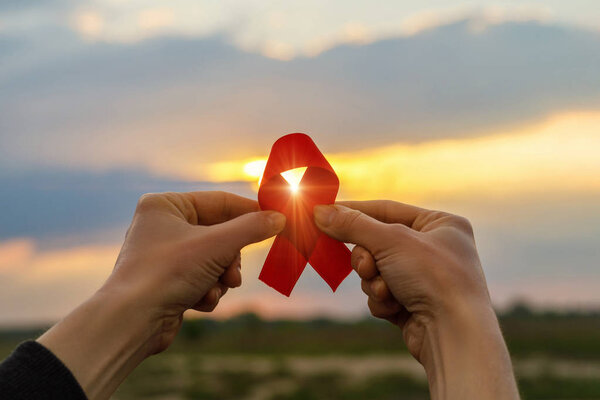 Aids red ribbon in hands .