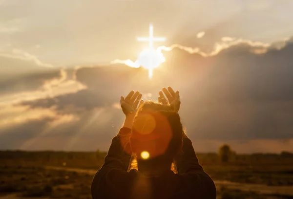 The woman extends her hand to the cross . — Stock Photo, Image