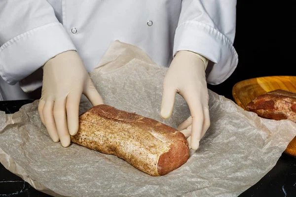 Lo chef avvolge la carne per l'essiccazione in carta da forno . — Foto Stock
