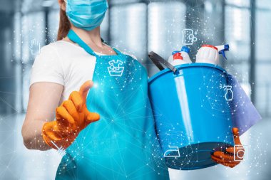 Temizlikçi kadın bulanık bir arkaplanda temizlik servisi simgelerine tıklıyor..