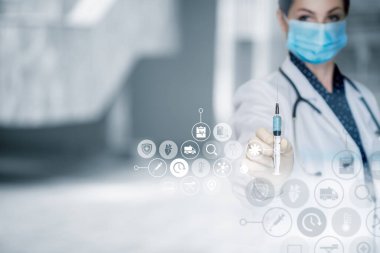 Doktor bulanık arka planda aşısı olan bir şırınga gösteriyor..