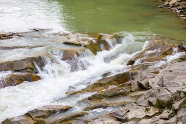Dalgalı akıntı ve bir dağ nehrinin küçük şelalesi.