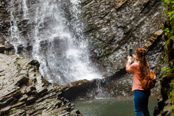 Mulher Turista Fotografa Uma Cachoeira Fundo Uma Rocha — Fotografia de Stock