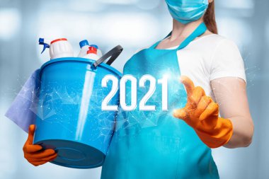 Temizlik hizmetleri için yeni yıl 2021. Maskeli temizlikçi kadın 2021 numaraya tıklıyor..