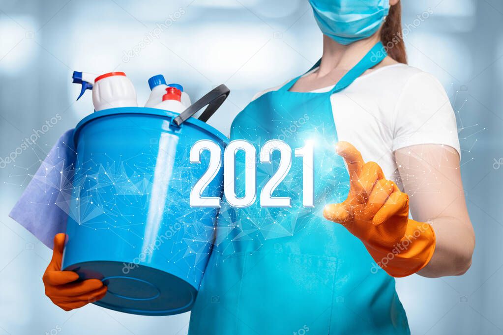 New year 2021 for cleaning services. The masked cleaning lady clicks on the number 2021.