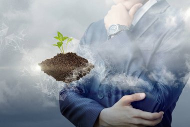 Yeryüzündeki filizlenme ve gökyüzünün arka planında bir iş adamı.