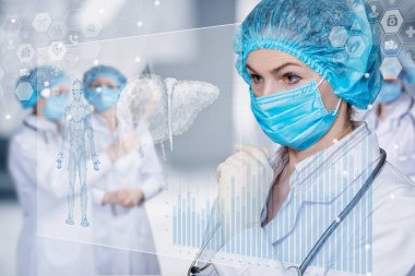 Doktor bulanık bir arkaplandaki hasta verilerine bakıyor..