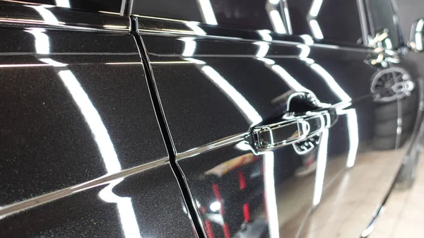 A clean black car, wheels, tires, headlights