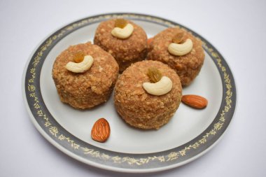 Laddu 'ya yakın çekim ya da ladoo buğday unundan yapılmış ve festivalde Ganesh chaturthi prasad gibi tabakta servis edilen tereyağlı ghee, kuru meyveli fındık ve beyaz badem ile süslenmiş diwali.
