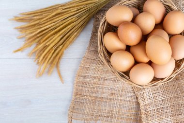 Yumurta beyaz ahşap bir masa üzerinde ahşap sepet içinde.