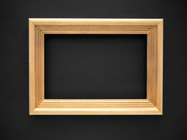 Gold colored wooden frame isolated on a black background. for photos, text, images or paintings — Stock Photo, Image