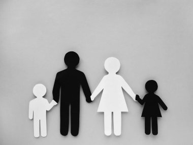 Siyah beyaz kağıttan kesilmiş bir aile ve insanın sembolü. Irklar arası aile. Mesaj için yer var. karışık ırk evliliği