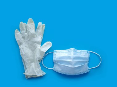 Antivirüs koruması. Mavi arka planda lastik eldivenler ve tıbbi maske. Gripten korunma. Ncov-19 koronavirüs salgını.