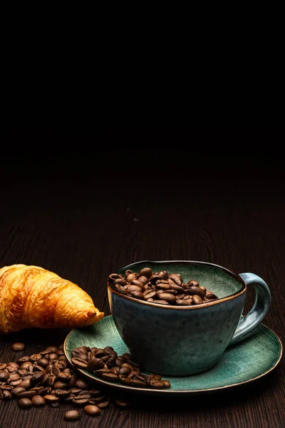 Taza con granos de café sobre un fondo negro —  Fotos de Stock