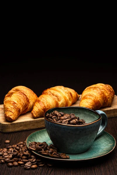 Tasse mit Kaffeebohnen auf schwarzem Hintergrund — Stockfoto