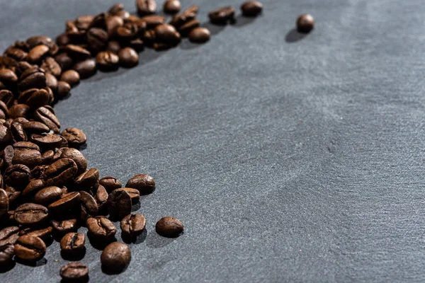 Um espalhamento de grãos de café torrados na hora — Fotografia de Stock