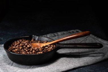 Dökme demir tavada taze kavrulmuş kahve çekirdekleri.