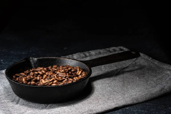 Grãos de café recém-torrados em uma frigideira de ferro fundido — Fotografia de Stock