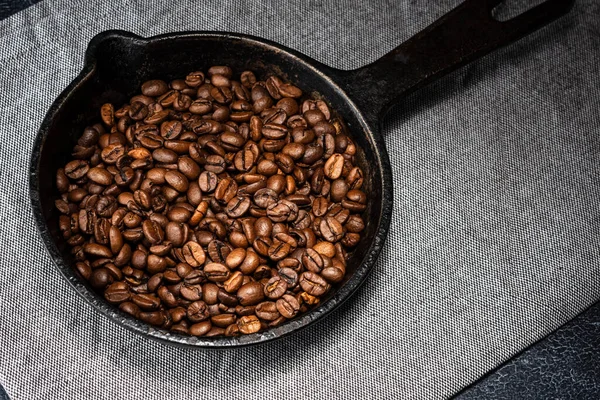 Grãos de café recém-torrados em uma frigideira de ferro fundido — Fotografia de Stock