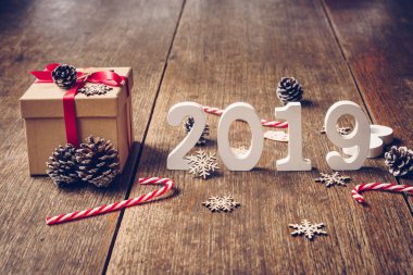 Üstten görünüm ahşap numaraları numarası 2019, rustik ahşap hediye kutusu ve kırmızı kurdele ve Noel dekorasyonu ile yeni yıl 2019 için şekillendirme.