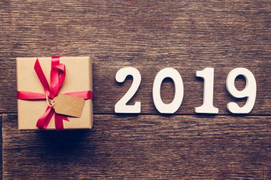 Ahşap numaraları numarası 2019, rustik ahşap hediye kutusu ve kırmızı kurdele ile yeni yıl 2019 için şekillendirme.