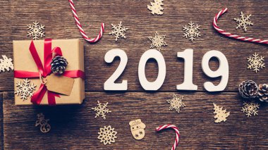 Üstten görünüm ahşap numaraları numarası 2019, rustik ahşap hediye kutusu ve kırmızı kurdele ve Noel dekorasyonu ile yeni yıl 2019 için şekillendirme.
