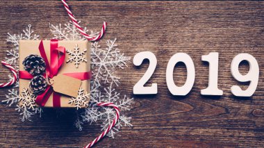 Üstten görünüm ahşap numaraları numarası 2019, rustik ahşap hediye kutusu ve kırmızı kurdele ve Noel dekorasyonu ile yeni yıl 2019 için şekillendirme.