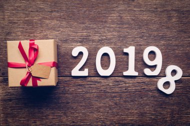 Üstten görünüm ahşap numaraları numarası 2019, rustik ahşap hediye kutusu ve kırmızı kurdele ile yeni yıl 2019 için şekillendirme.