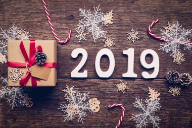 Üstten görünüm ahşap numaraları numarası 2019, rustik ahşap hediye kutusu ve kırmızı kurdele ve Noel dekorasyonu ile yeni yıl 2019 için şekillendirme.