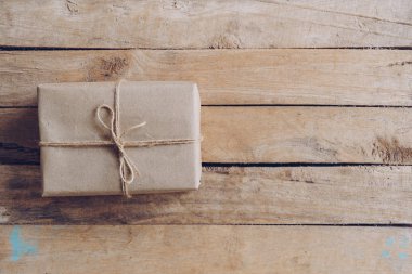 Kahverengi hediye kutusunun üstünde ahşap masa arka plan kopya alanı ile.