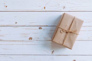 Kahverengi hediye kutusunun üstünde ahşap masa arka plan kopya alanı ile.