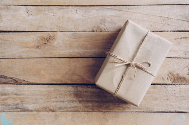 Kahverengi hediye kutusunun üstünde ahşap masa arka plan kopya alanı ile.