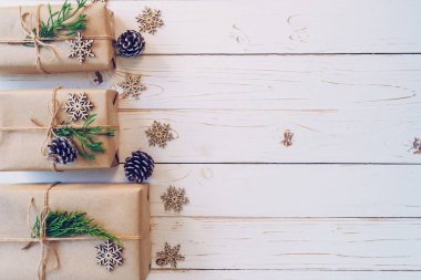 Alanı bir ahşap masa zemin üzerine ev yapımı kaydırılan Noel hediye kutusu sunar.