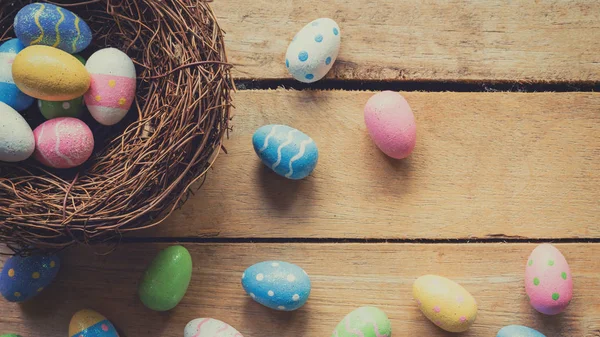 Цветные пасхальные яйца аккуратно на деревянном фоне с спа — стоковое фото