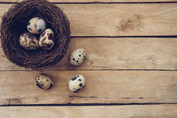 Ninho de madeira e ovos de páscoa em fundo de madeira e textura com — Fotografia de Stock