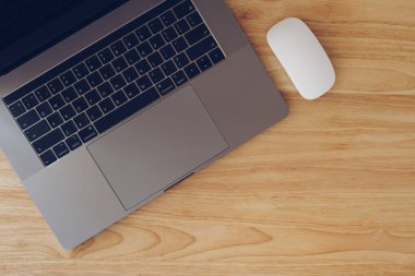 Kopyalama alanı ile ahşap masa üstü görünümünde dizüstü bilgisayar ve fare.