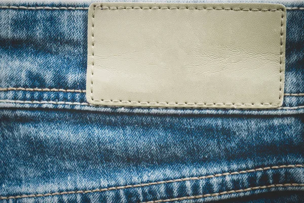 Leeres Lederetikett auf Jeans-Hintergrund mit Kopierraum — Stockfoto