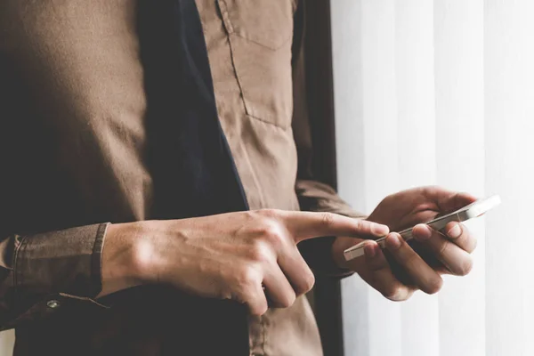 Businessman holding phone at window. Creative Business Startup I