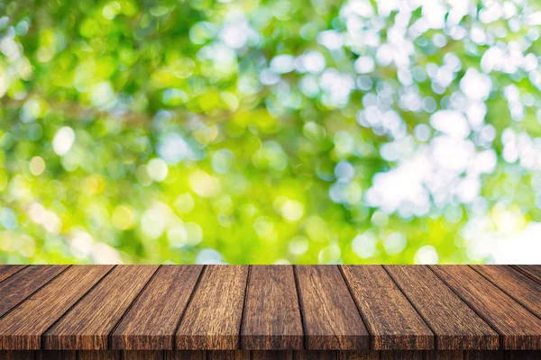 空の木製のテーブルと抽象的なぼやけた緑のボケの葉の葉 — ストック写真