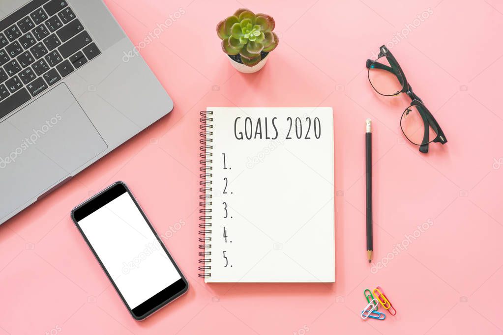 2020 New year concept. Goals list in stationery, laptop, noteboo