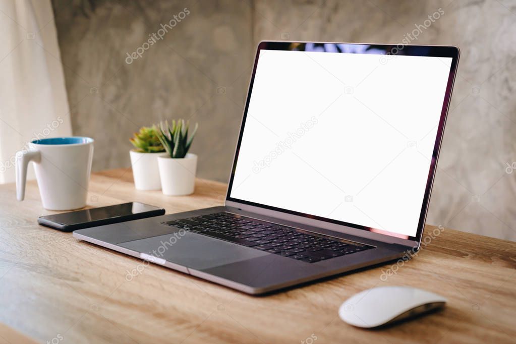 Laptop computer with blank screen on table.