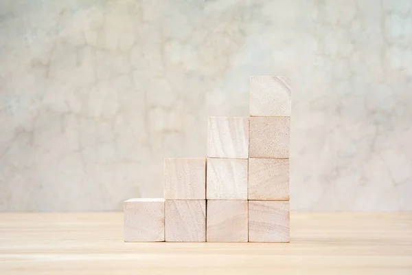 Wooden toy cubes on wooden table ang grey background