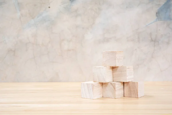 Wooden toy cubes on wooden table ang grey background
