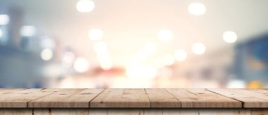 Gösteri, promosyon ve tasarım konsepti için ahşap masa tezgahı arka planına sahip mağazanın soyut bulanık görüntüsü
