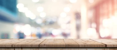 Gösteri, promosyon ve tasarım konsepti için ahşap masa tezgahı arka planına sahip mağazanın soyut bulanık görüntüsü