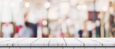 Gösteri, promosyon ve tasarım konsepti için ahşap masa tezgahı arka planına sahip mağazanın soyut bulanık görüntüsü