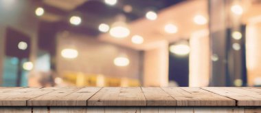 Gösteri, promosyon ve tasarım konsepti için ahşap masa tezgahı arka planına sahip mağazanın soyut bulanık görüntüsü