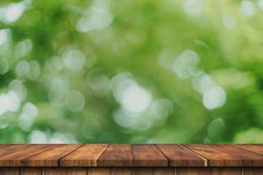 Ürün için boş ahşap tablo ve yeşil bokeh bulanıklığı kopyalama alanı görüntüleme montajı.