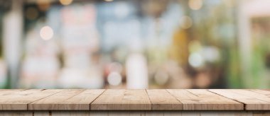 Boş ahşap masa ve kahve dükkanındaki bulanık ışık masası ve kafenin arka planı bokeh. ürün görüntüleme şablonu.